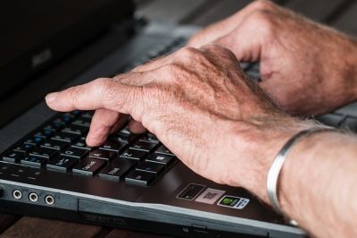 old hands on computer keyboard