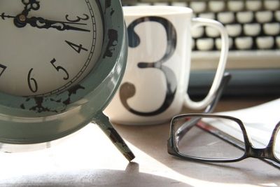 Clock, glasses and mug on desk