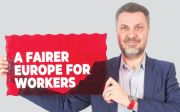 ETUC General Secretary Luca Visentini holds a sign saying: "A fairer Europe for workers"